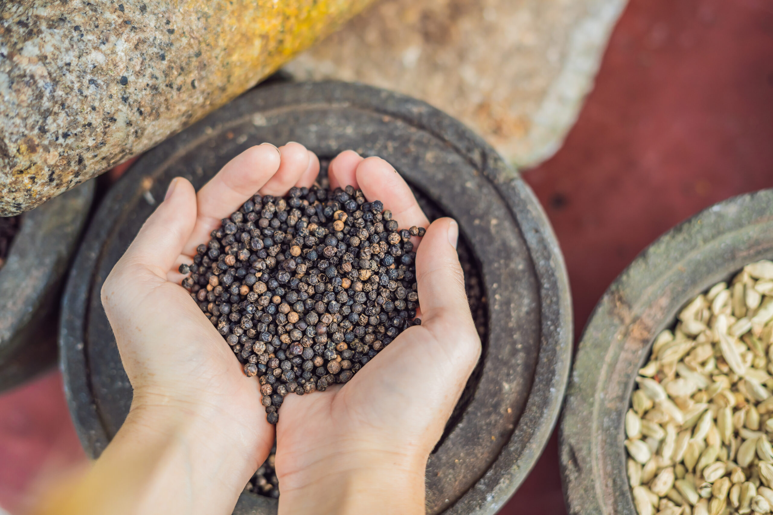 Black pepper female hands background spices scaled