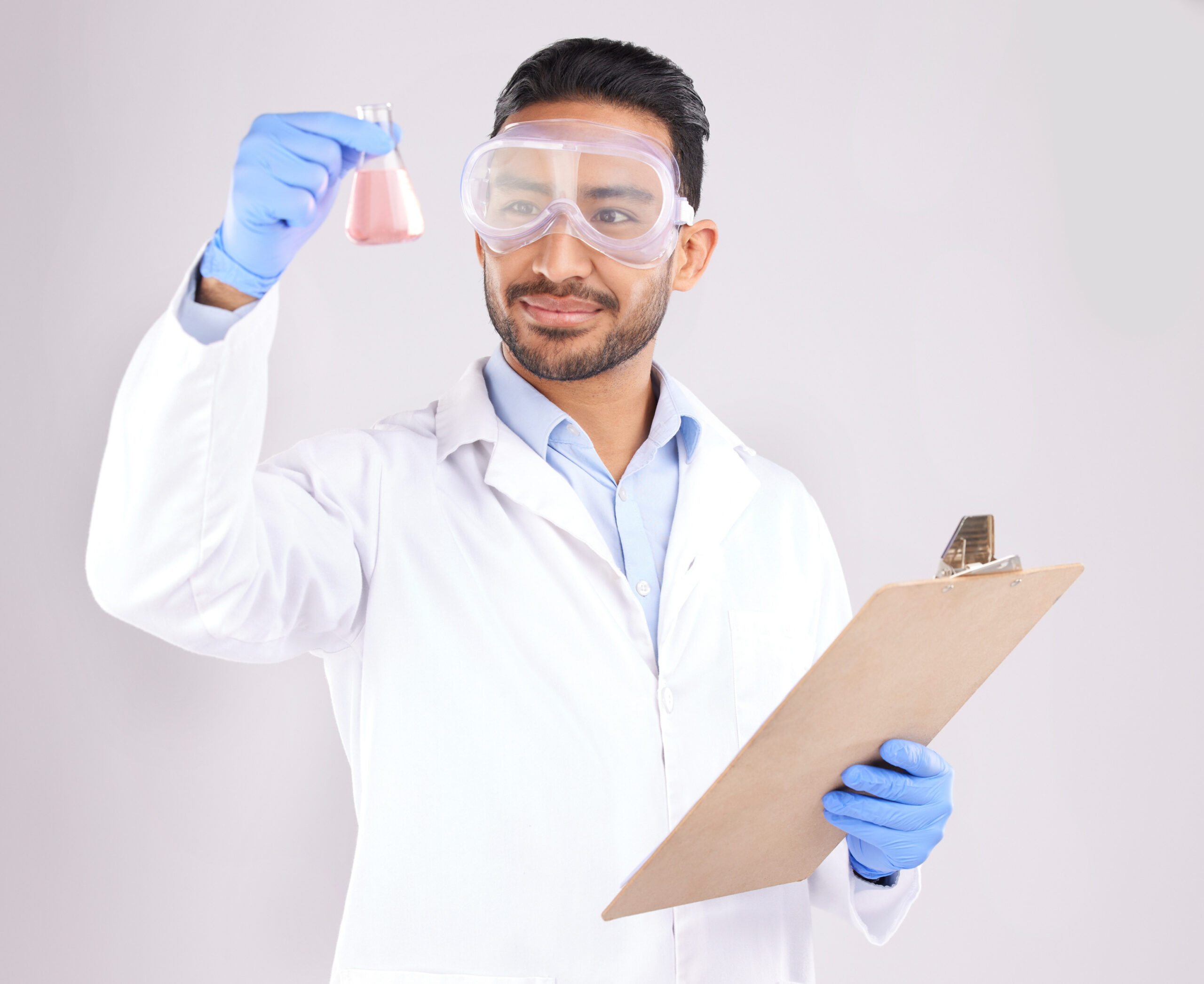 Scientist man beaker thinking with checklist analysis ppe goggles studio by white background asian science expert clipboard paperwork chemistry ideas study pharma job scaled